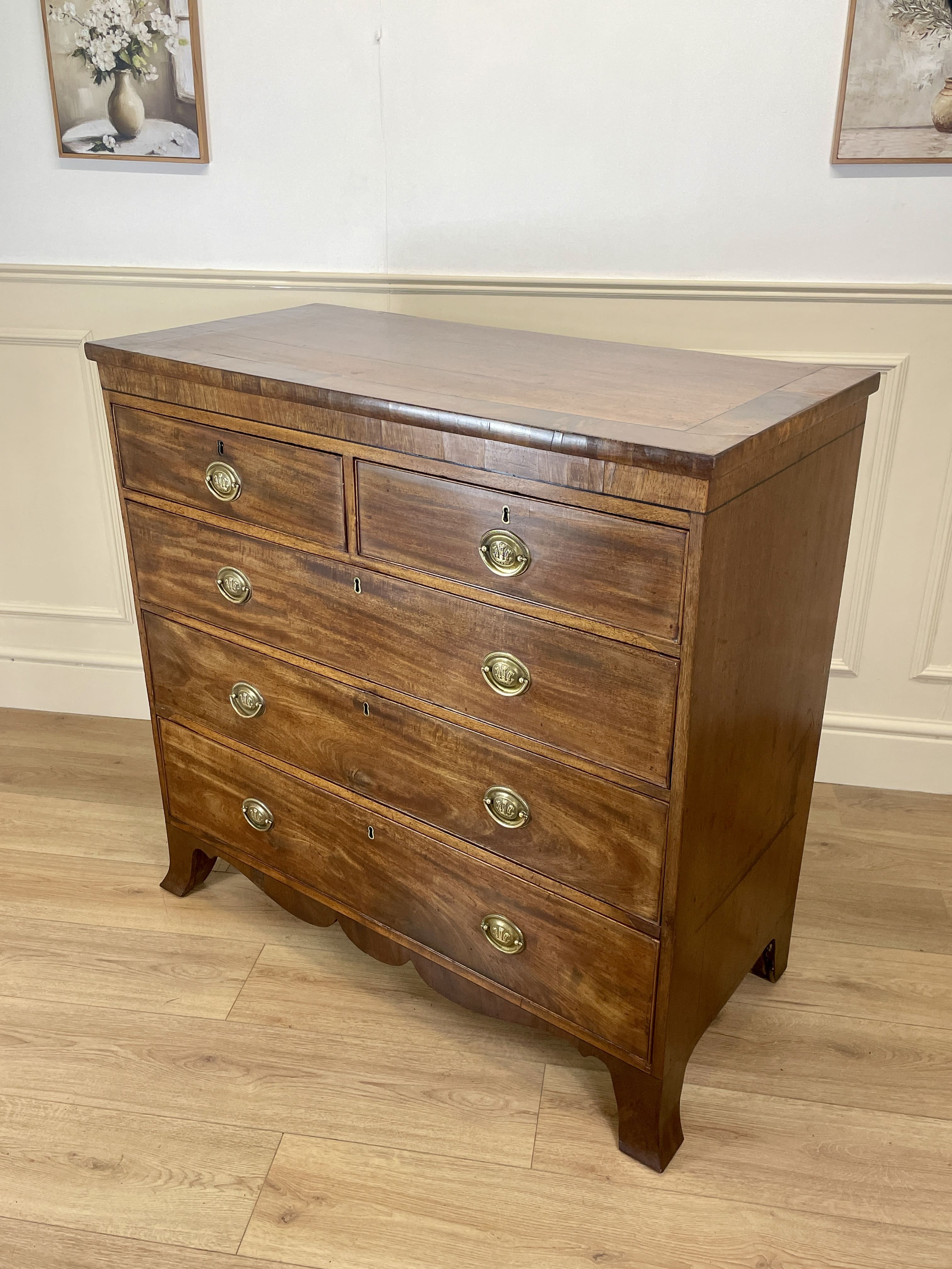 Angled view showing antique mahogany chest of drawers for bedroom with graduated drawers and Prince of Wales brasses