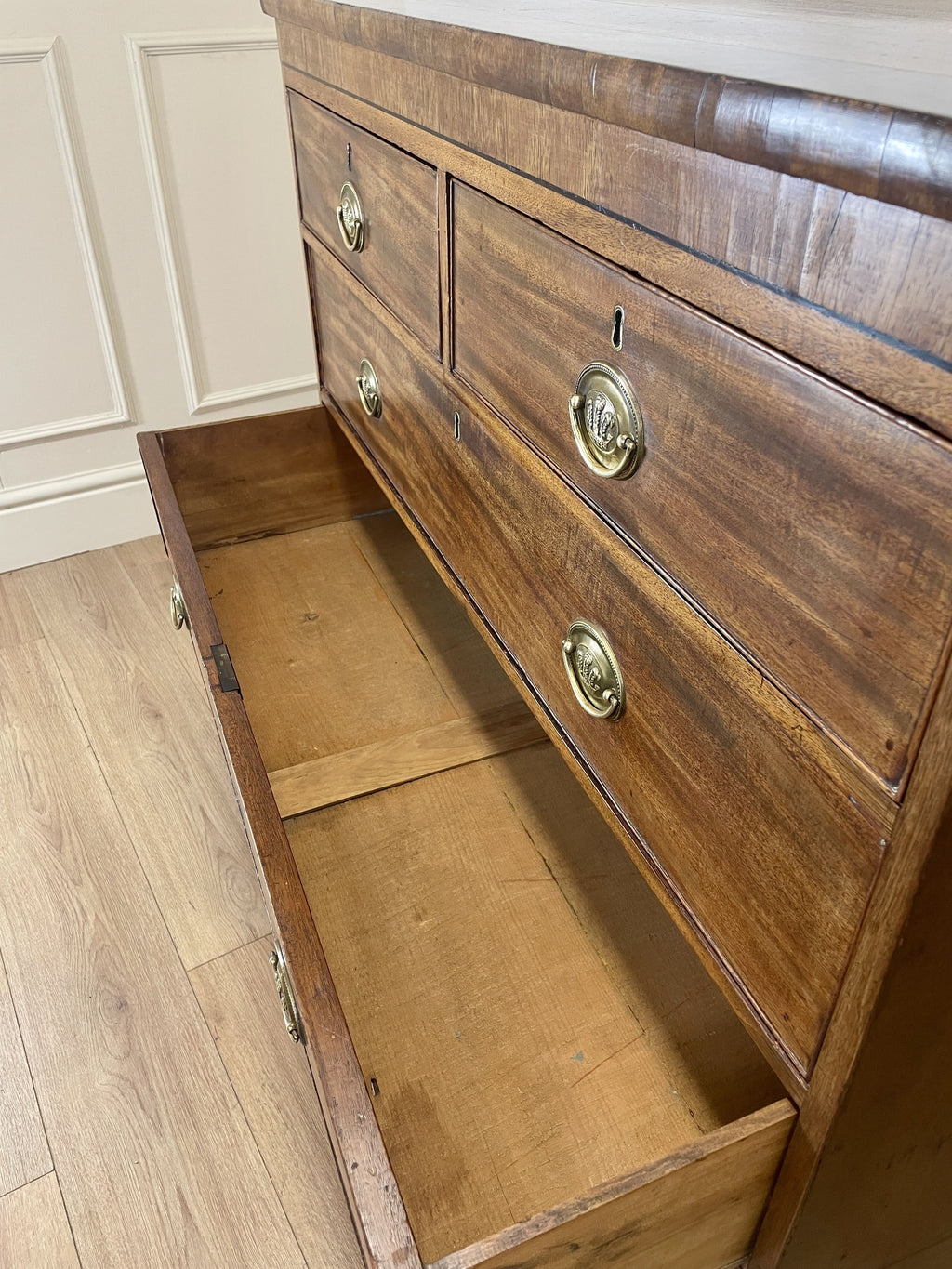 Angled view showing antique mahogany chest of drawers for bedroom with graduated drawers and Prince of Wales brasses