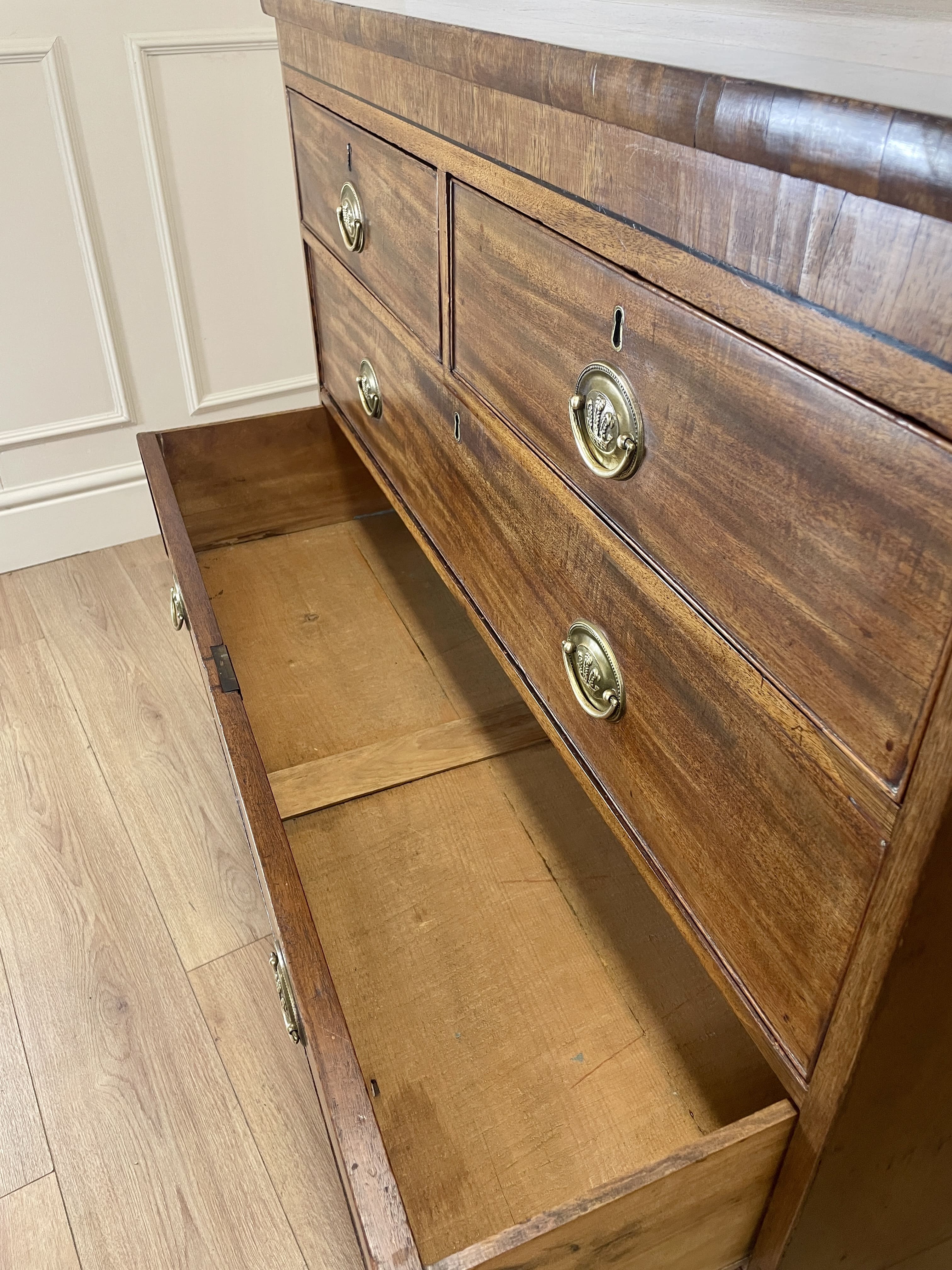 Angled view showing antique mahogany chest of drawers for bedroom with graduated drawers and Prince of Wales brasses
