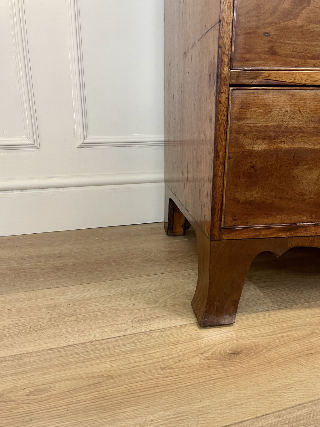 Angled view showing antique mahogany chest of drawers for bedroom with graduated drawers and Prince of Wales brasses
