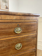 Angled view showing antique mahogany chest of drawers for bedroom with graduated drawers and Prince of Wales brasses