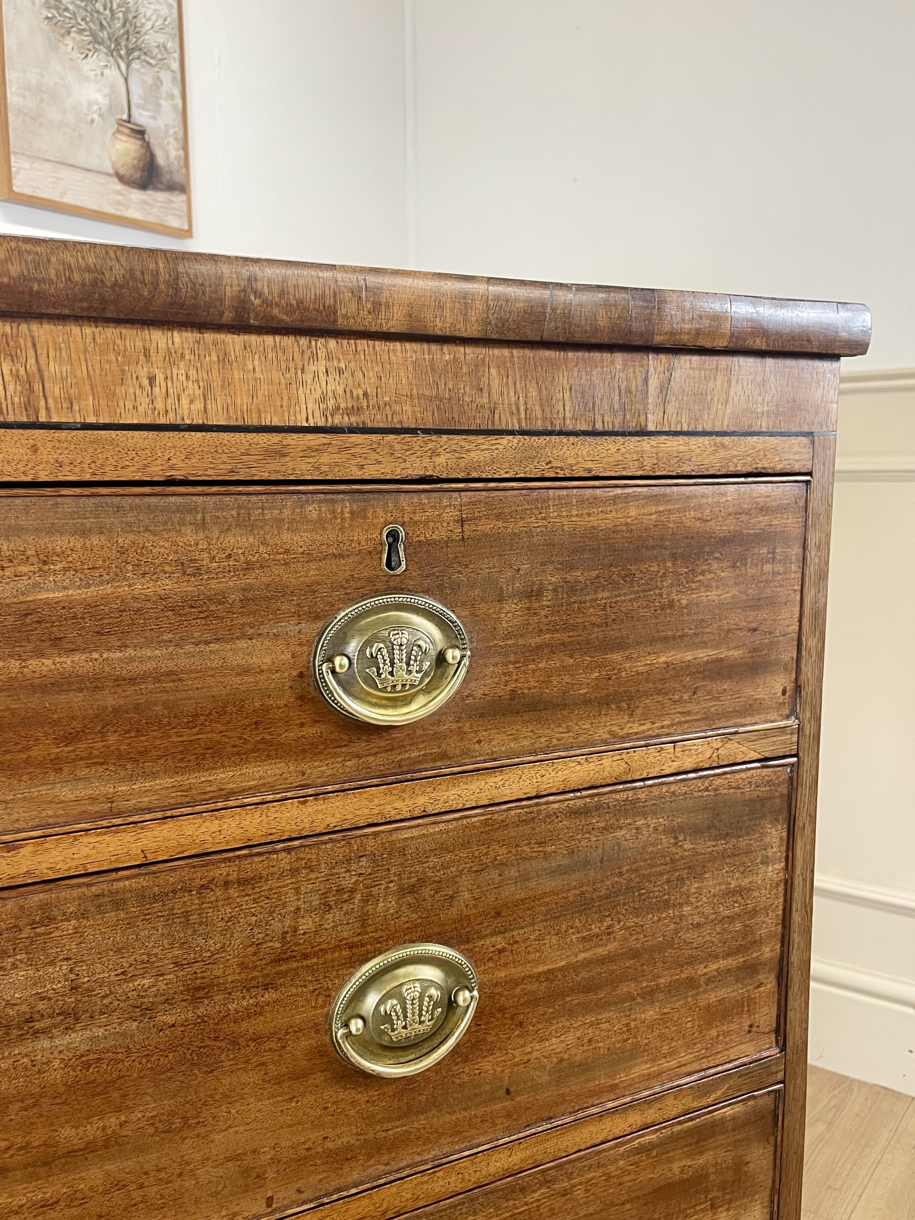 Angled view showing antique mahogany chest of drawers for bedroom with graduated drawers and Prince of Wales brasses