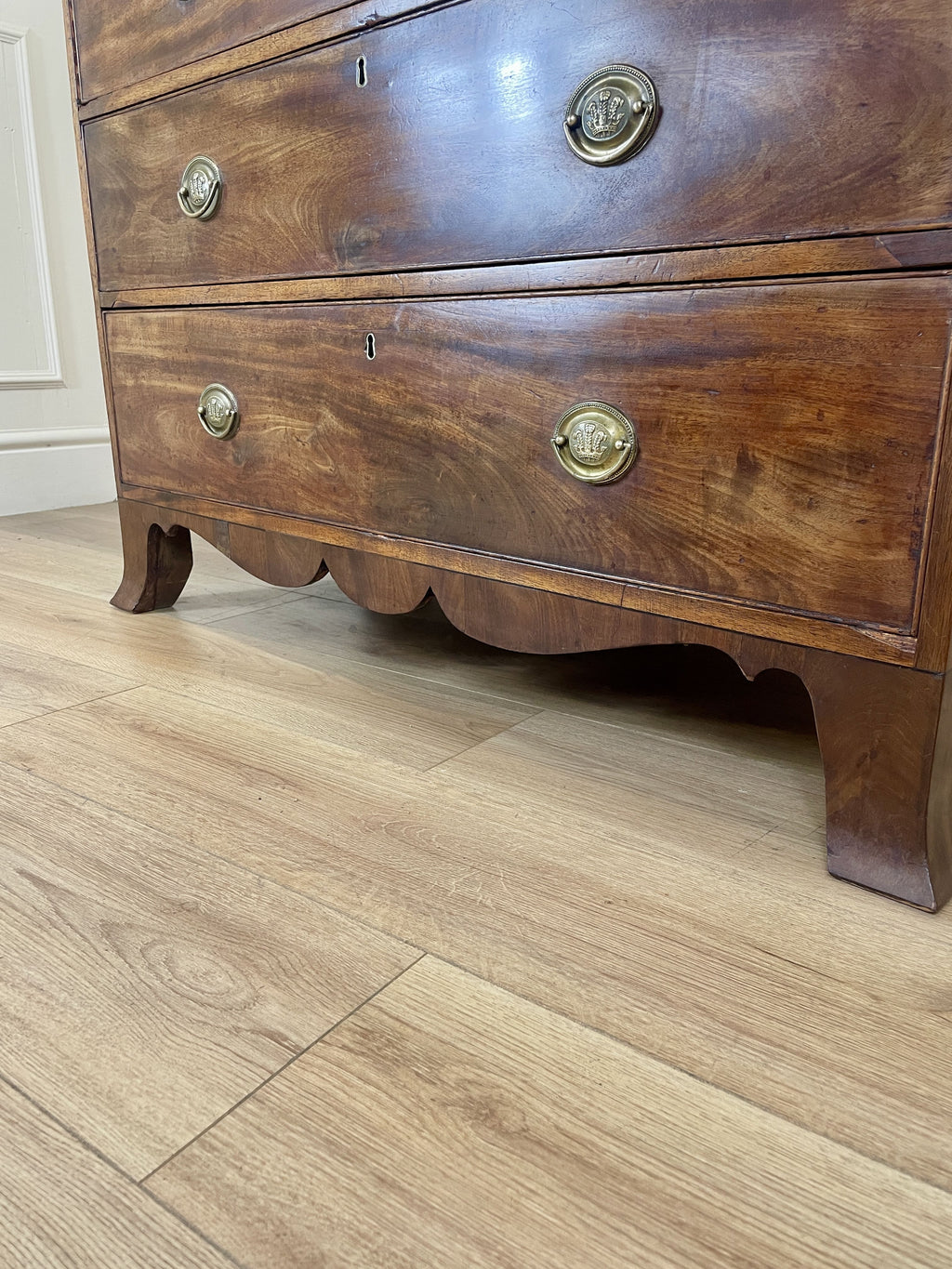 Angled view showing antique mahogany chest of drawers for bedroom with graduated drawers and Prince of Wales brasses