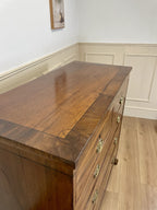 Angled view showing antique mahogany chest of drawers for bedroom with graduated drawers and Prince of Wales brasses