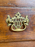 Decorative brass handle on a wooden surface