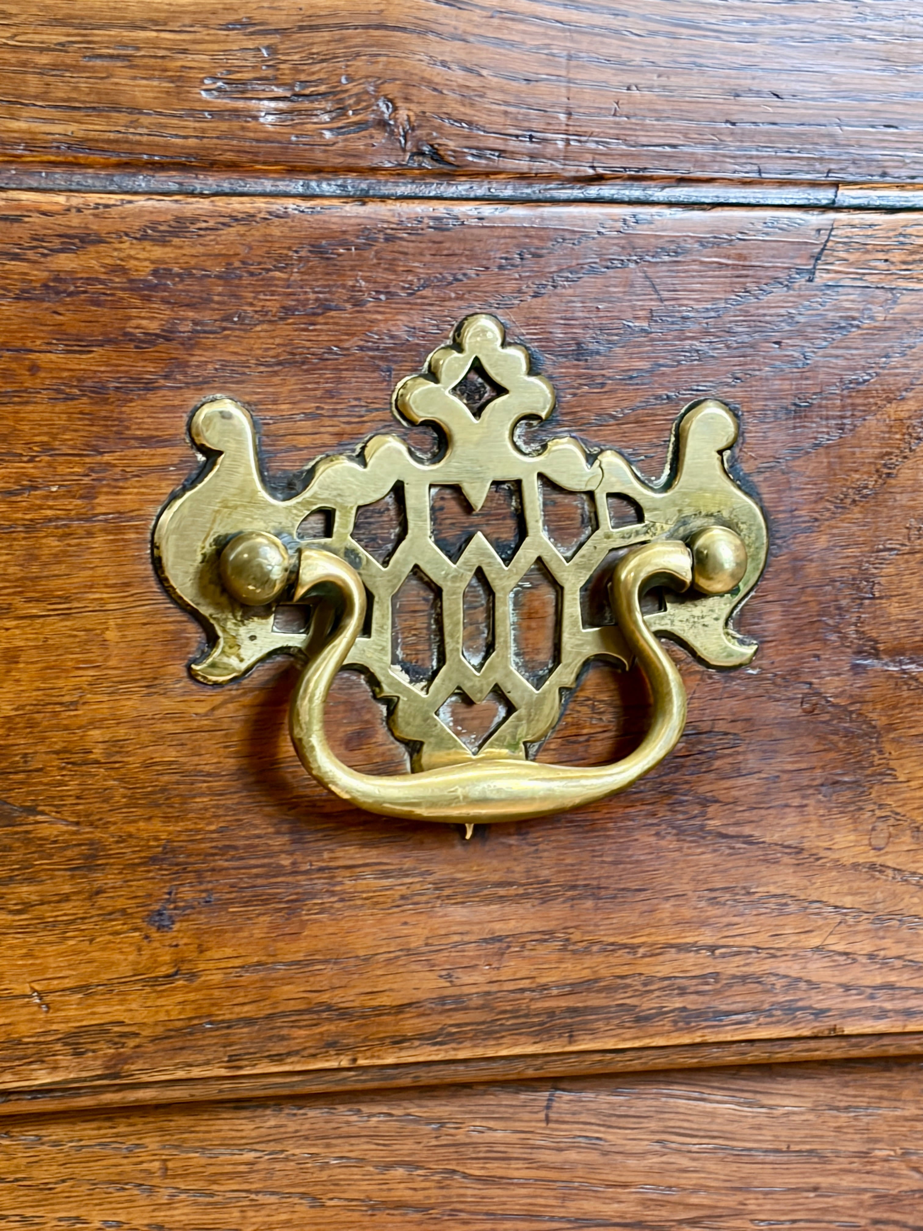 Decorative brass handle on a wooden surface
