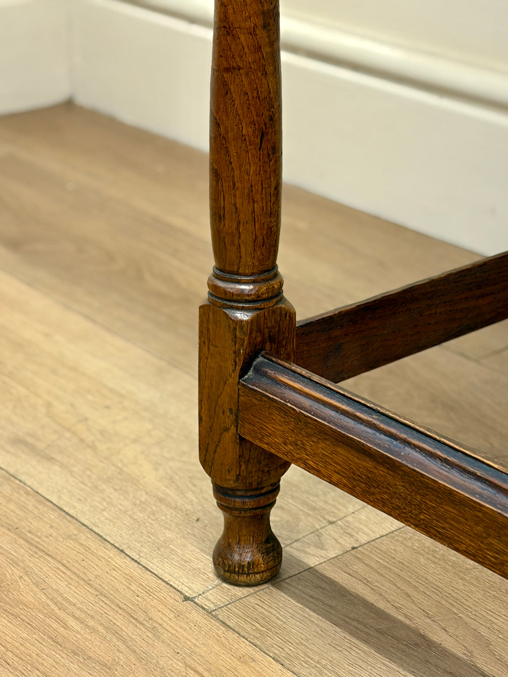 Close-up of a wooden chair leg on a wooden floor