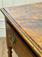 Close-up of a wooden desk with a brass handle.