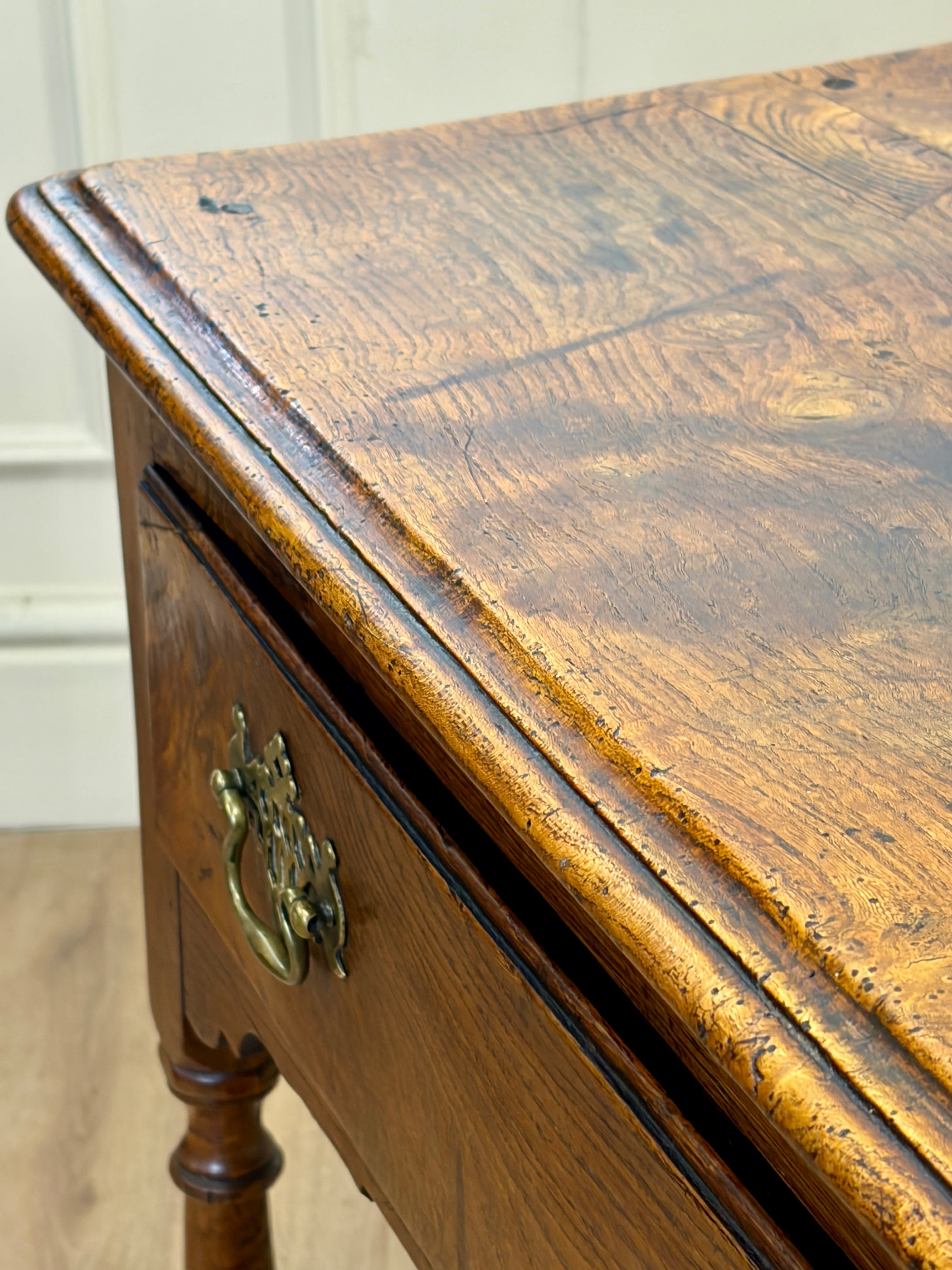 Close-up of a wooden desk with a brass handle.