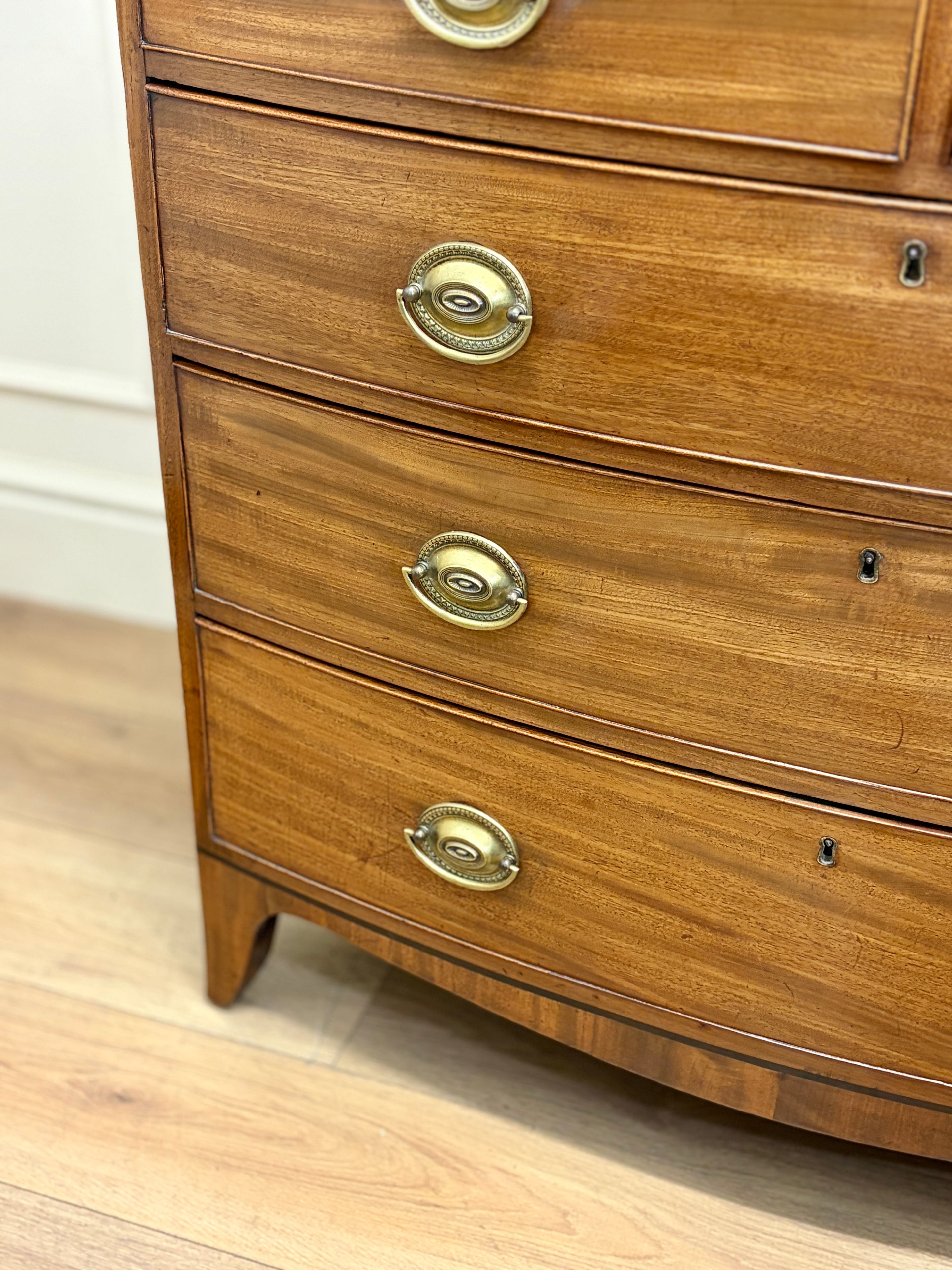 Wooden dresser with brass handles on a wooden floor.