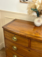 Wooden dresser with brass handles on a white wall background