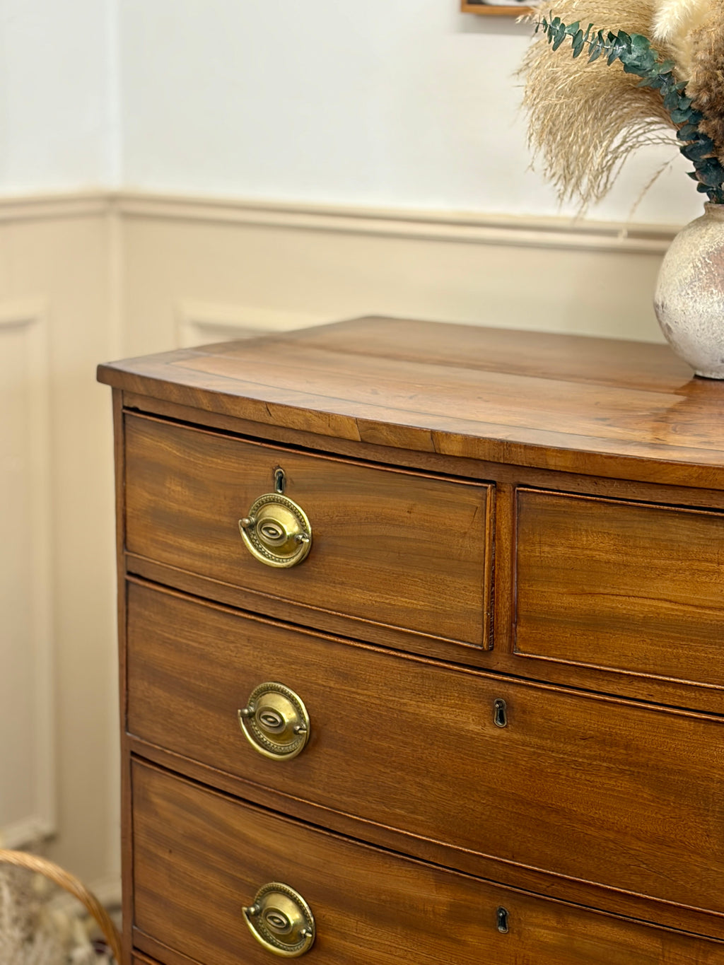 Wooden dresser with brass handles in a room setting