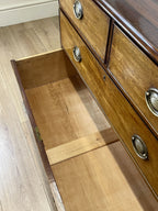 Angled view of late 19th century mahogany farmhouse chest of drawers with shaped bracket feet and elegant country furniture styling.