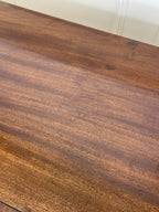 Angled view of late 19th century mahogany farmhouse chest of drawers with shaped bracket feet and elegant country furniture styling.