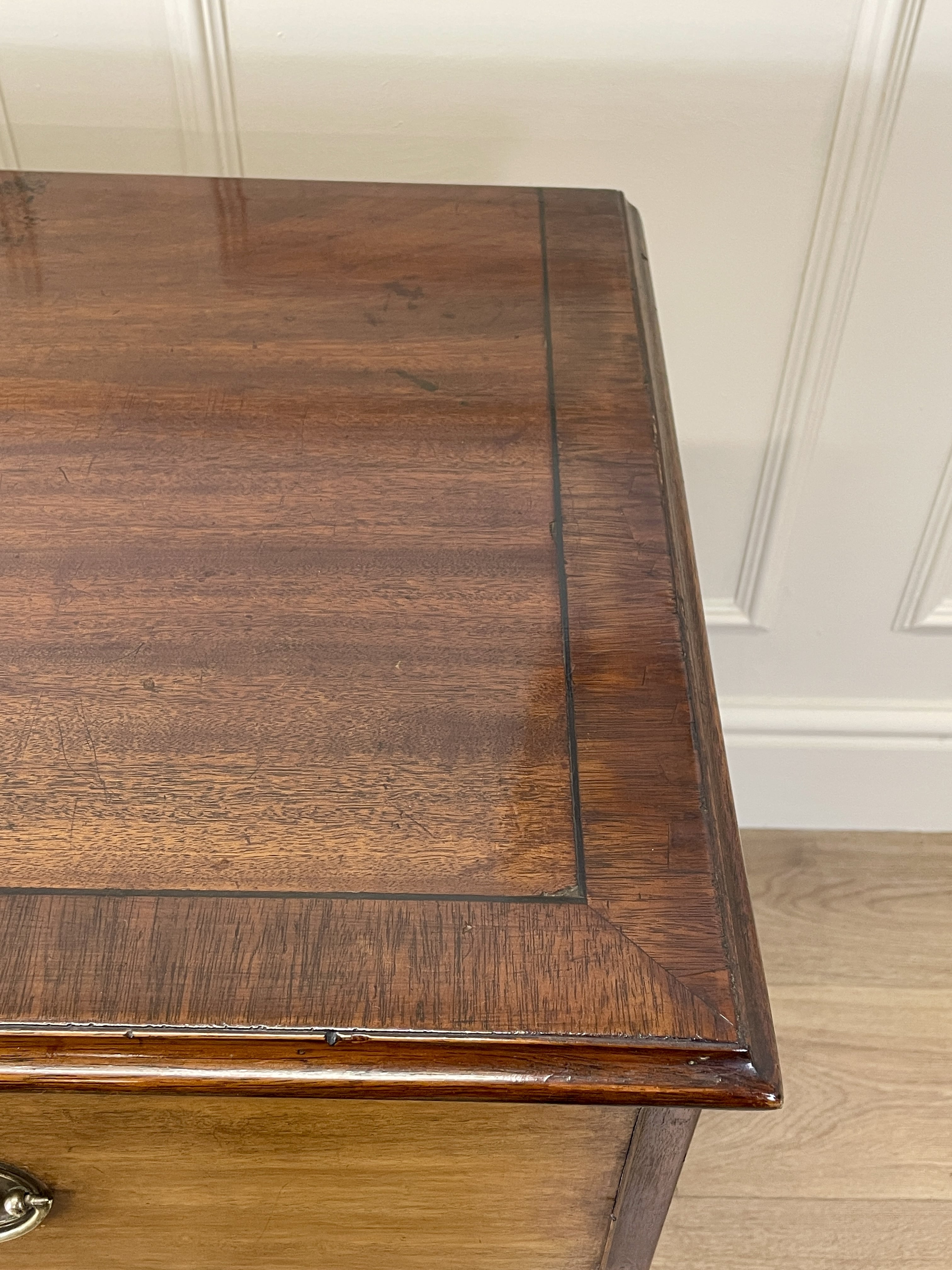 Angled view of late 19th century mahogany farmhouse chest of drawers with shaped bracket feet and elegant country furniture styling.