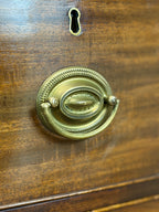 Close-up of a wooden door with a brass doorknob and keyhole.