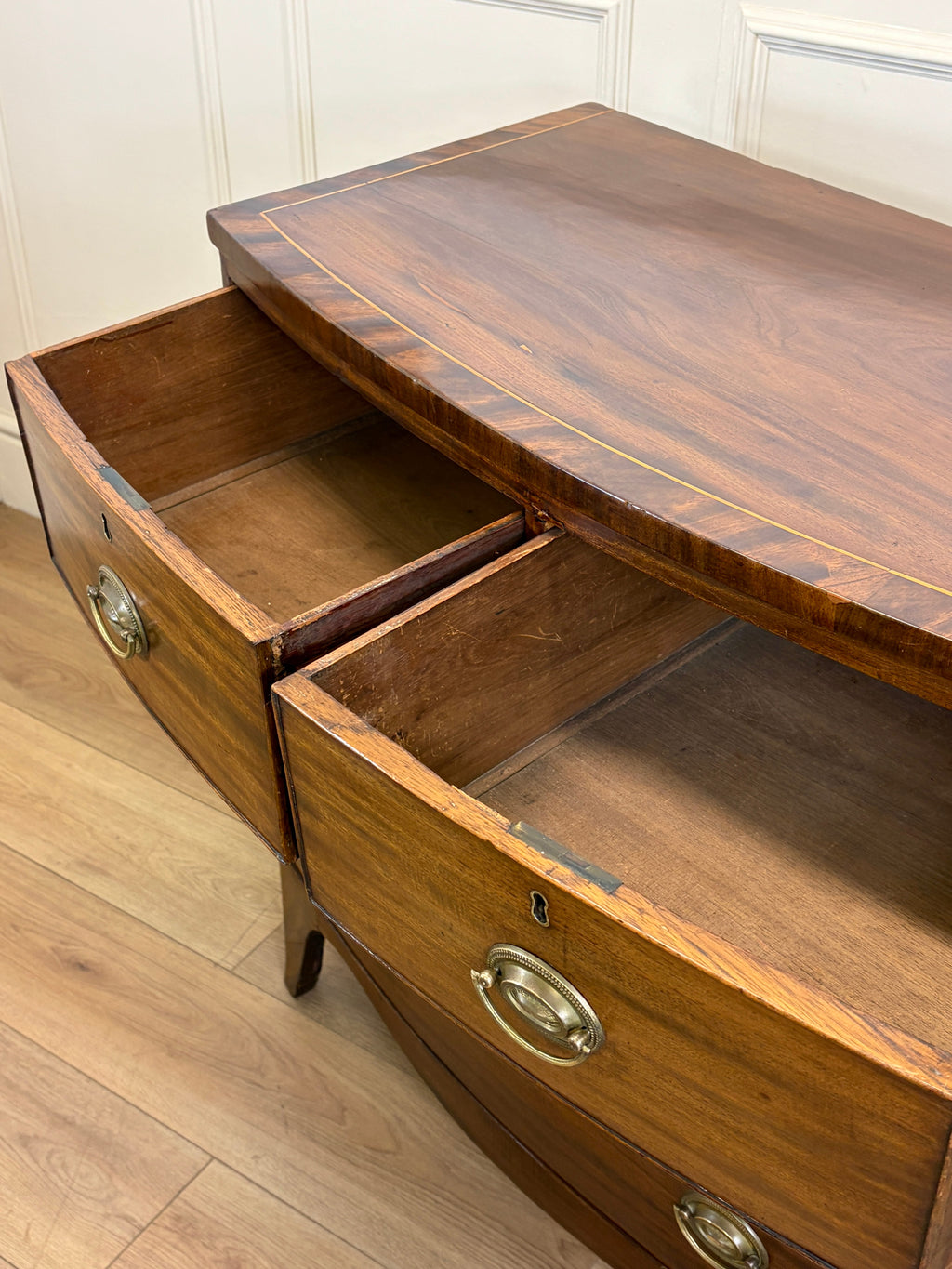 Wooden dresser with open drawer on a wooden floor
