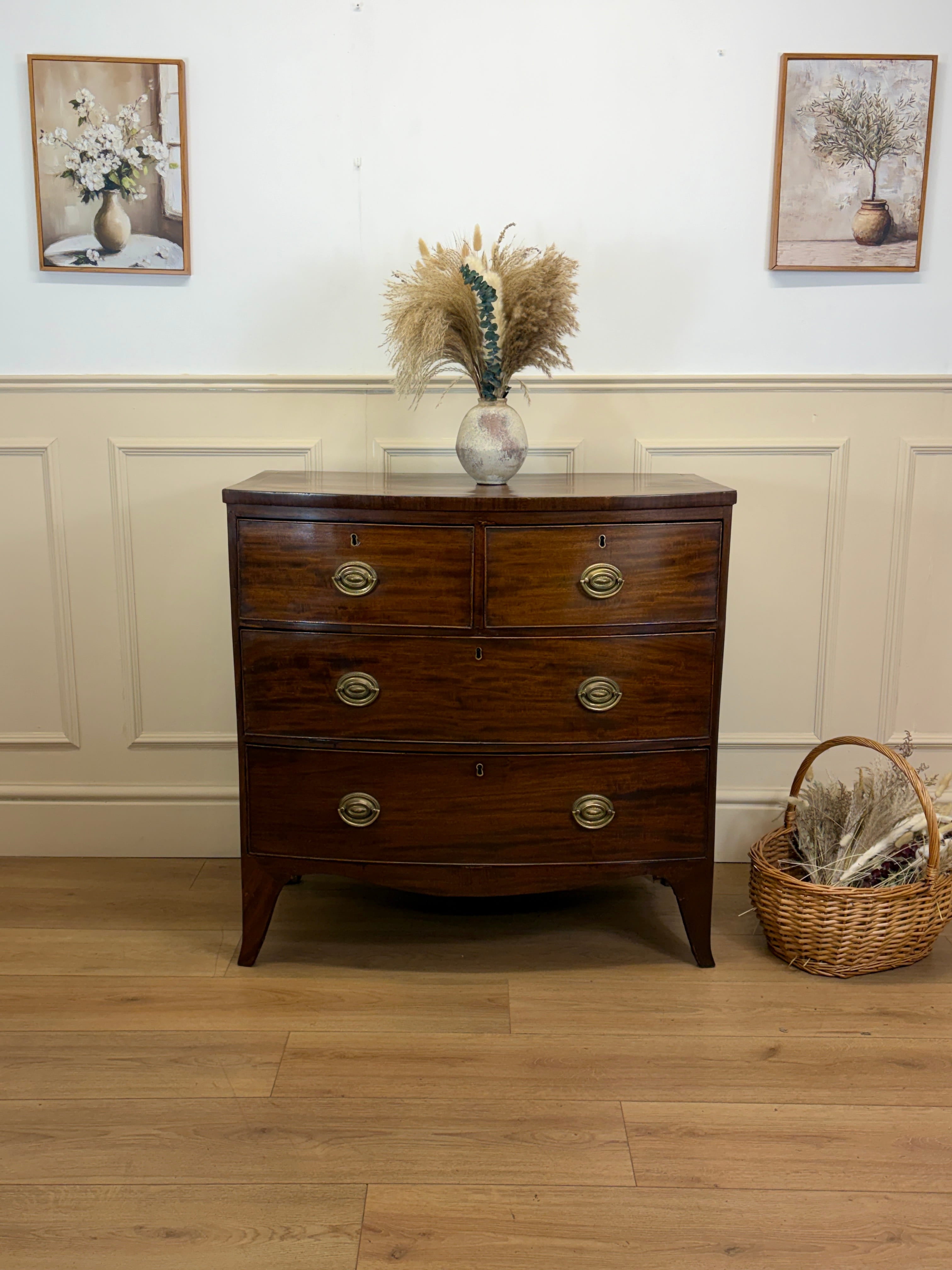 Wooden dresser with decorative items in a room with framed pictures on the wall.