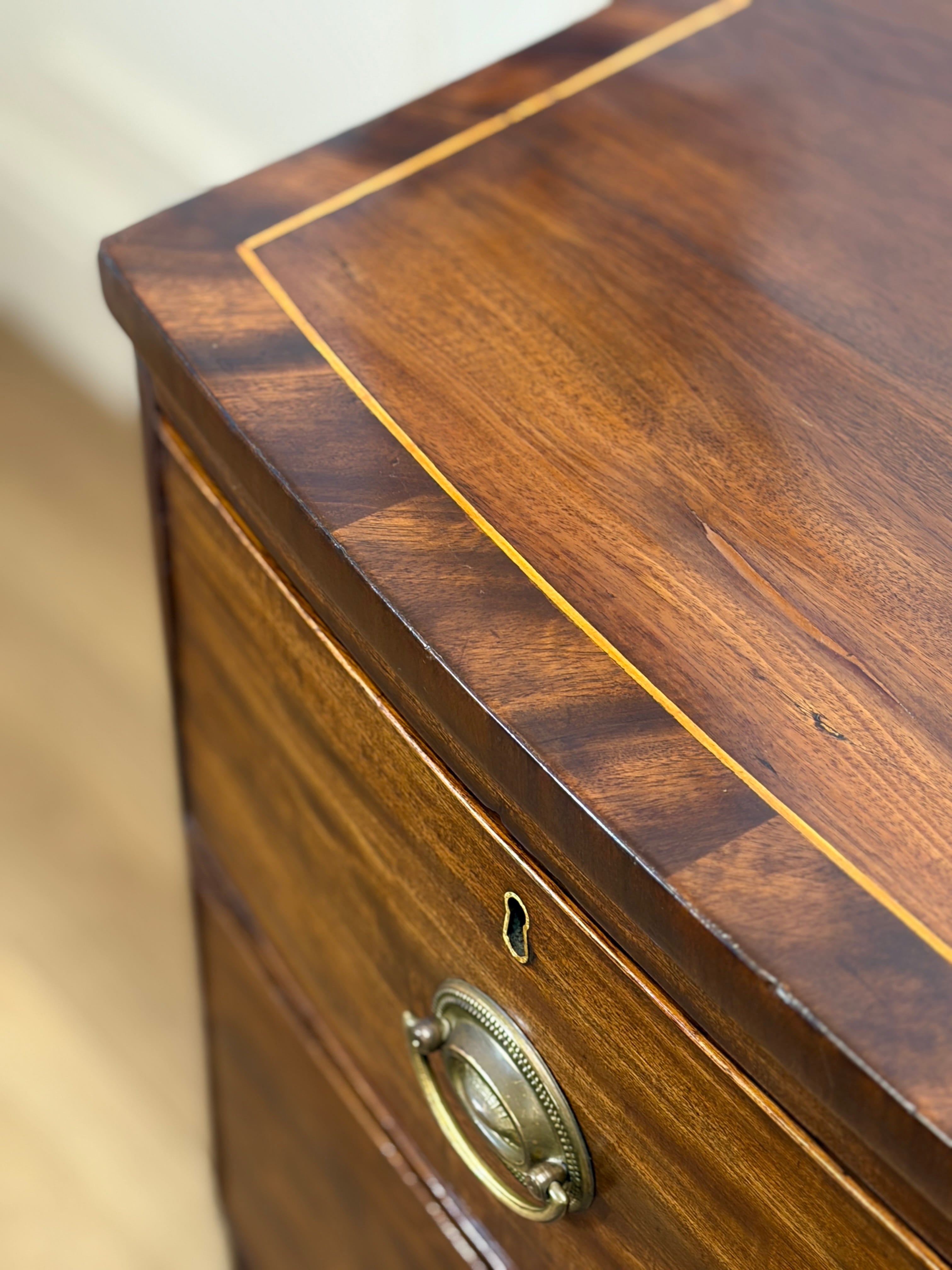 Close-up of a wooden drawer with a brass handle on a light background