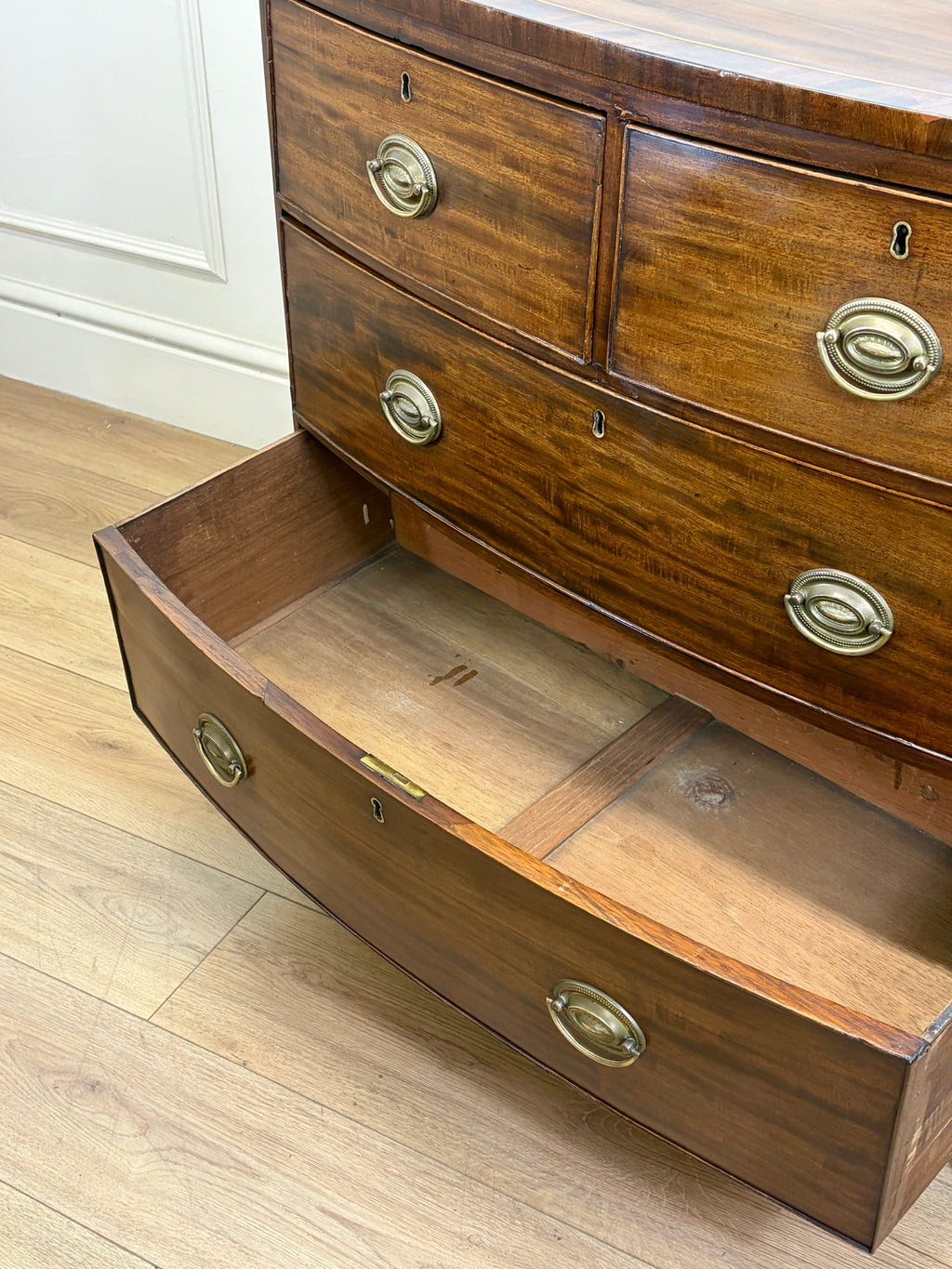 Wooden dresser with open drawer on a wooden floor