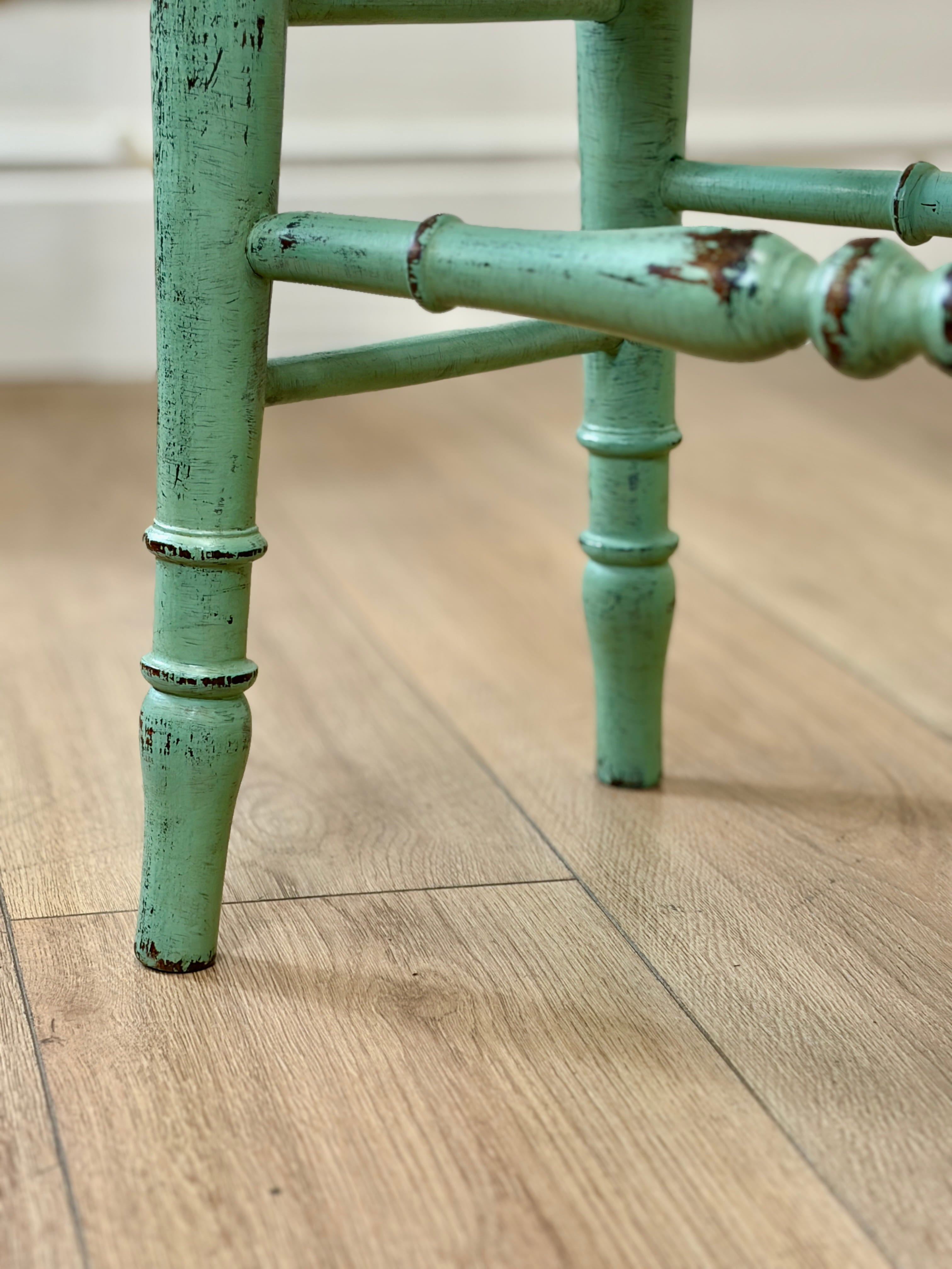 Green metal chair leg on a wooden floor
