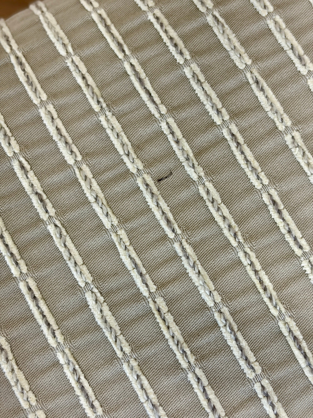 Close-up of a woven fabric with horizontal stripes in beige and white.