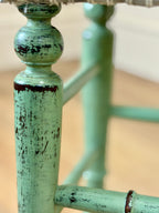 Close-up of a green metal chair with peeling paint