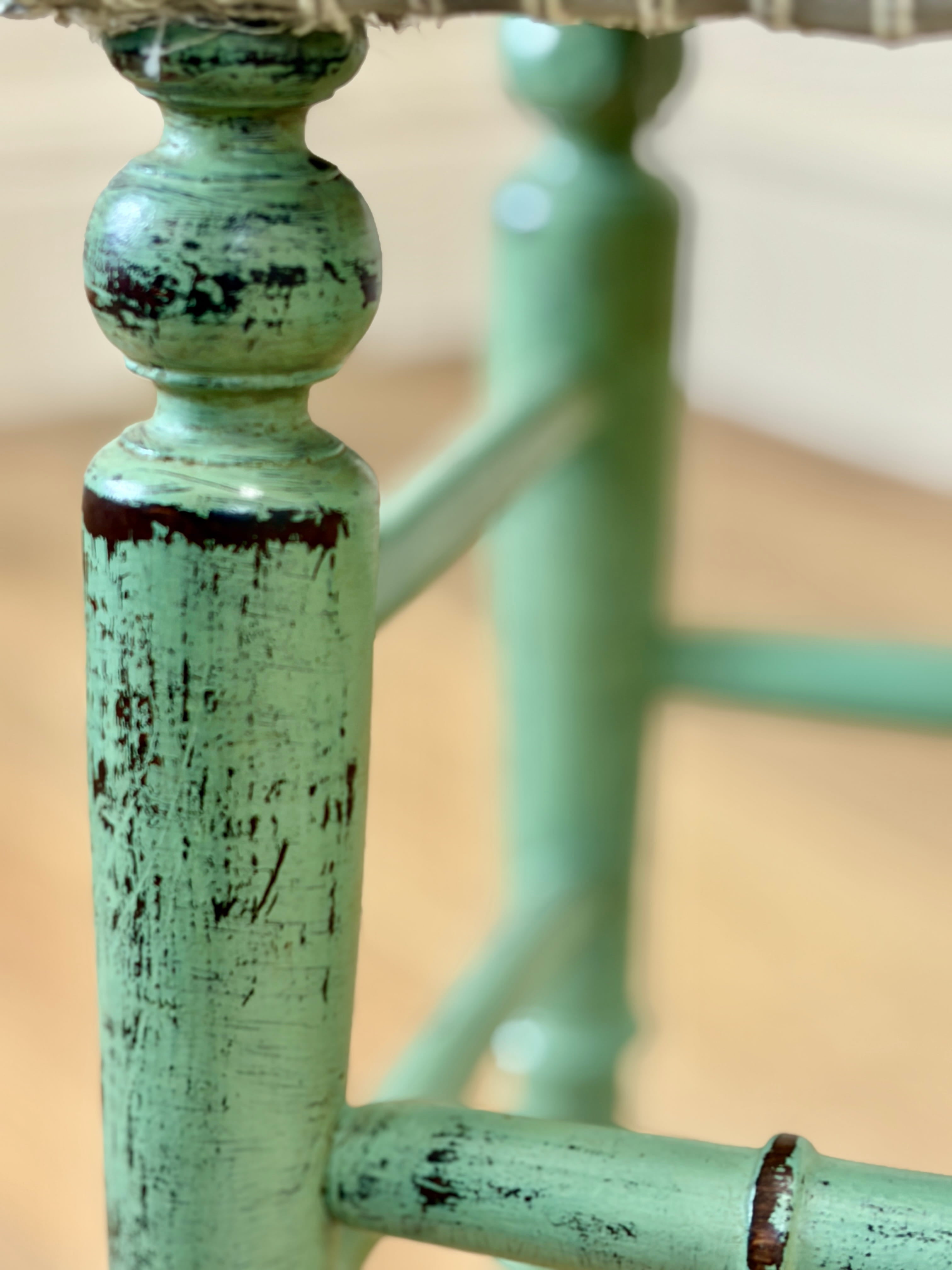 Close-up of a green metal chair with peeling paint