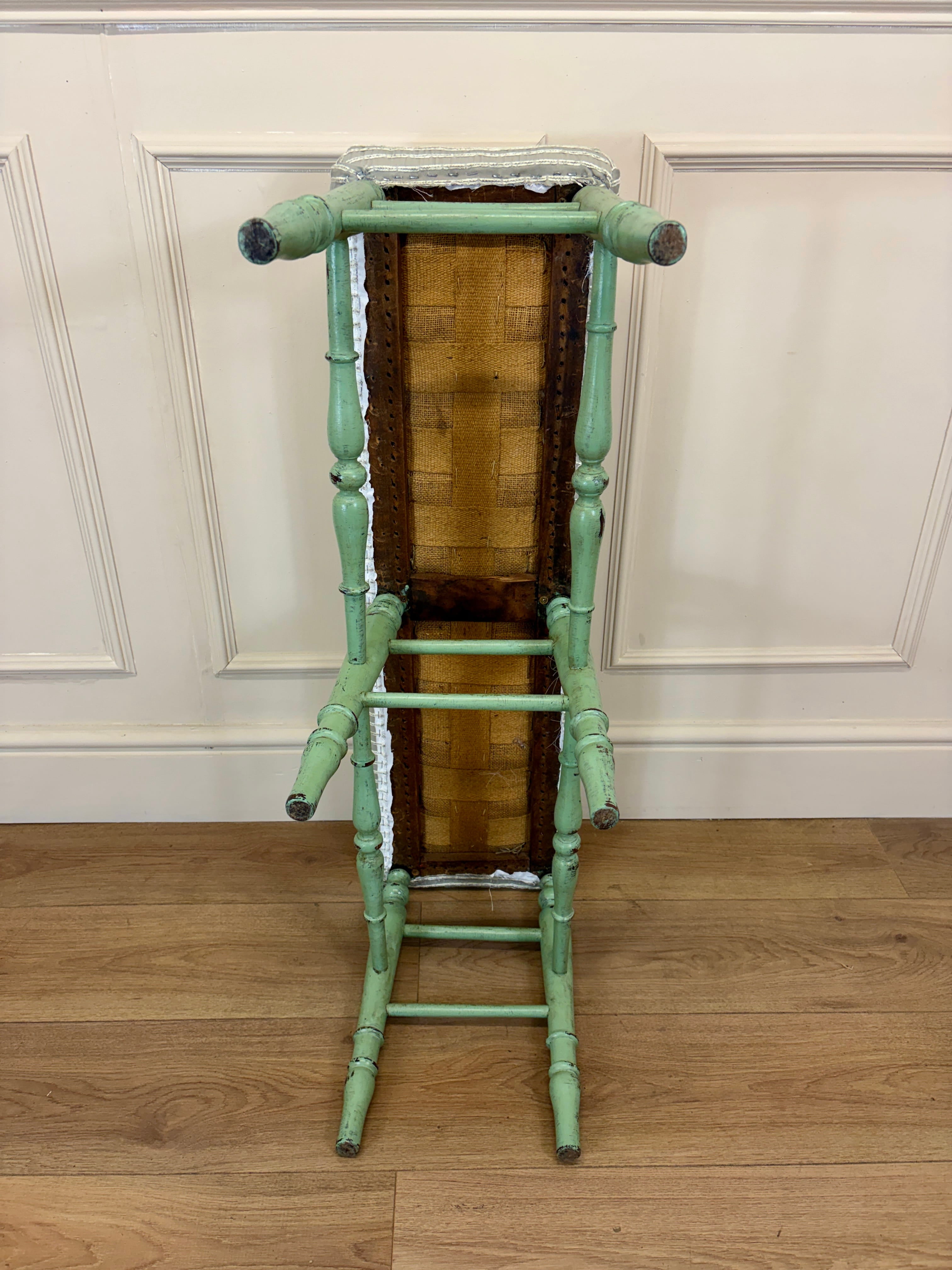 Green bamboo-style ladder against a white paneled wall.