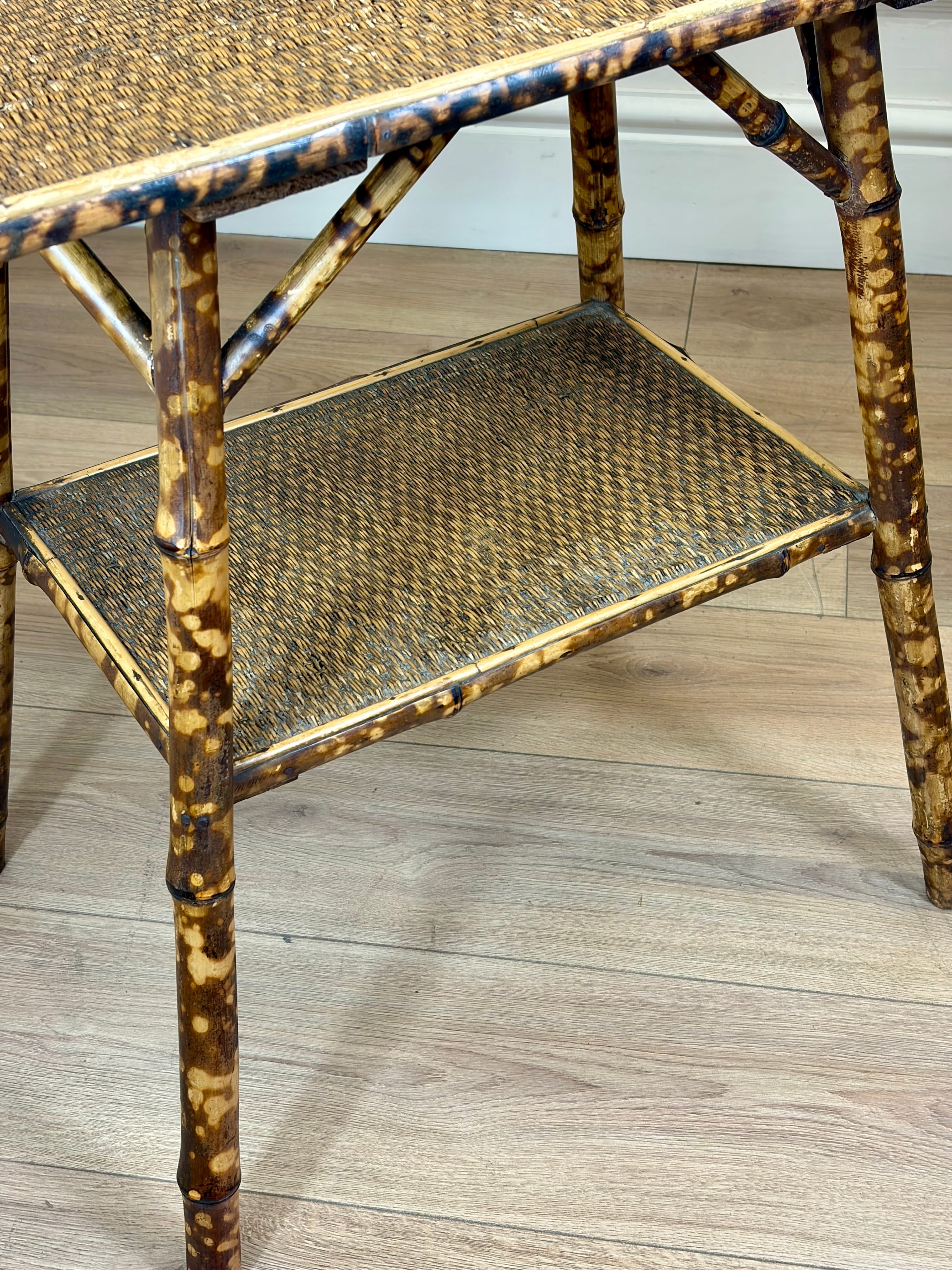 Bamboo side table with woven shelves on a wooden floor.