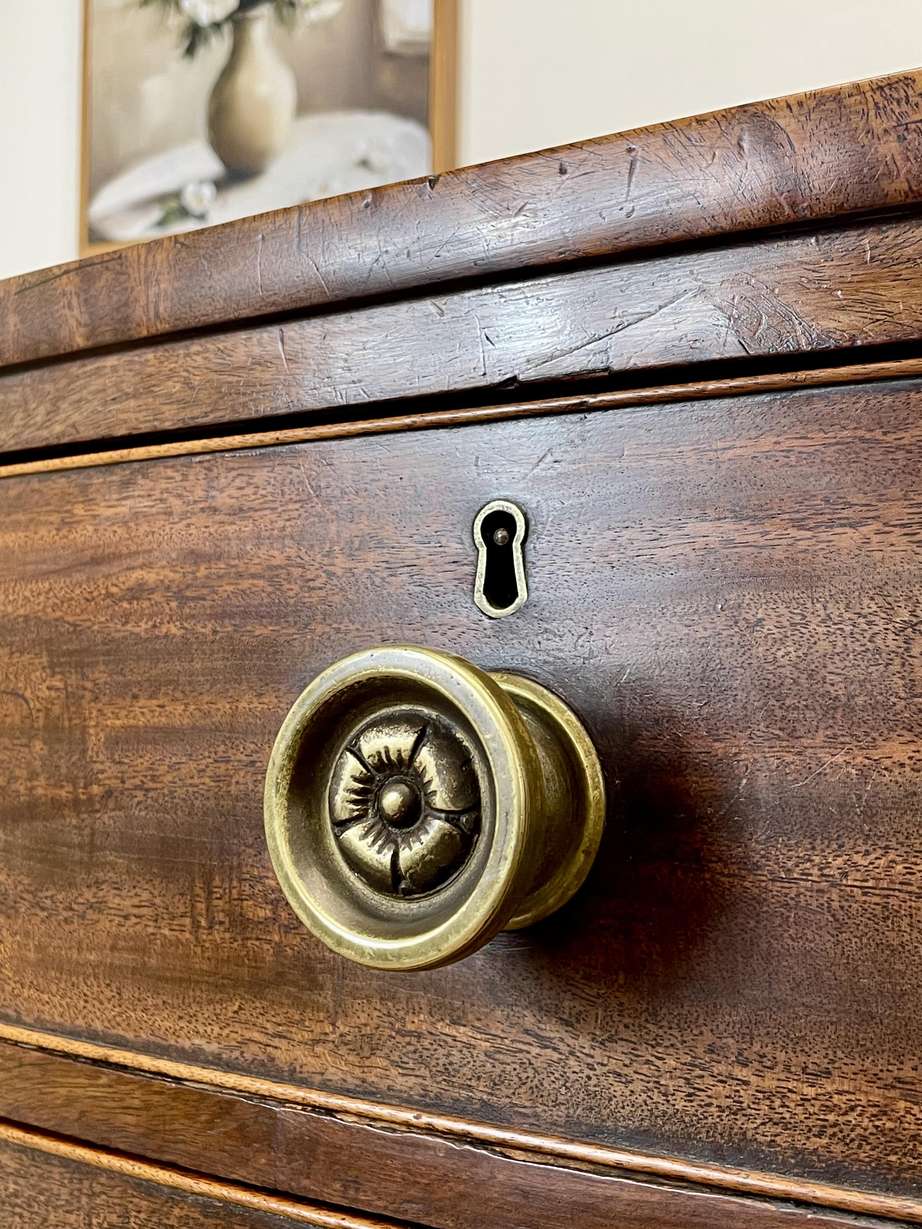 Close-up of a wooden drawer with a brass handle and keyhole.