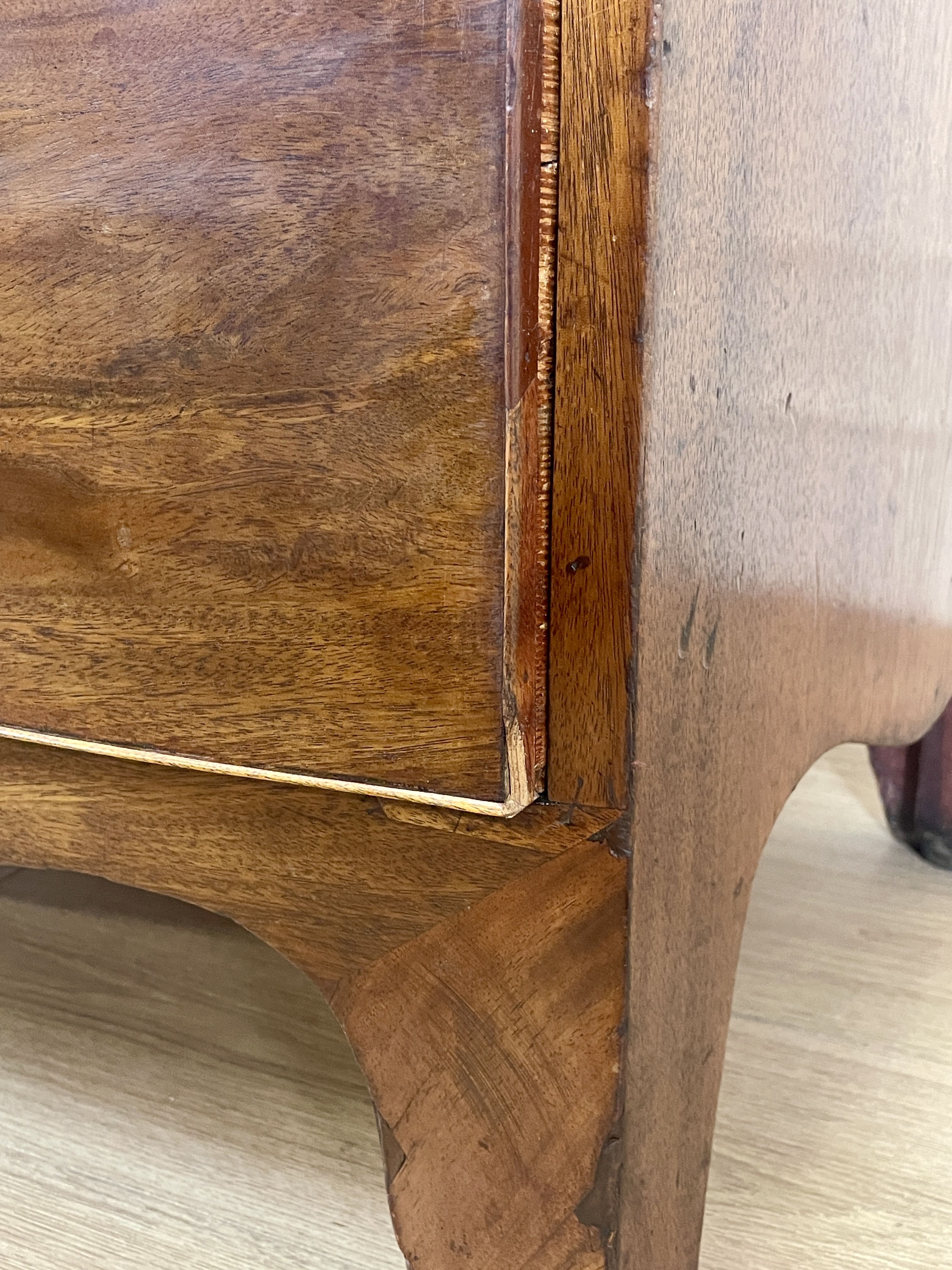 Close-up of a wooden furniture corner with a visible grain pattern.