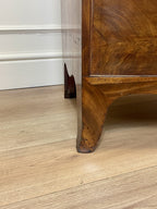 Wooden furniture leg on a wooden floor with a white wall in the background