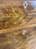 Close-up of a wooden cabinet with a keyhole lock, showing the wood grain and texture.