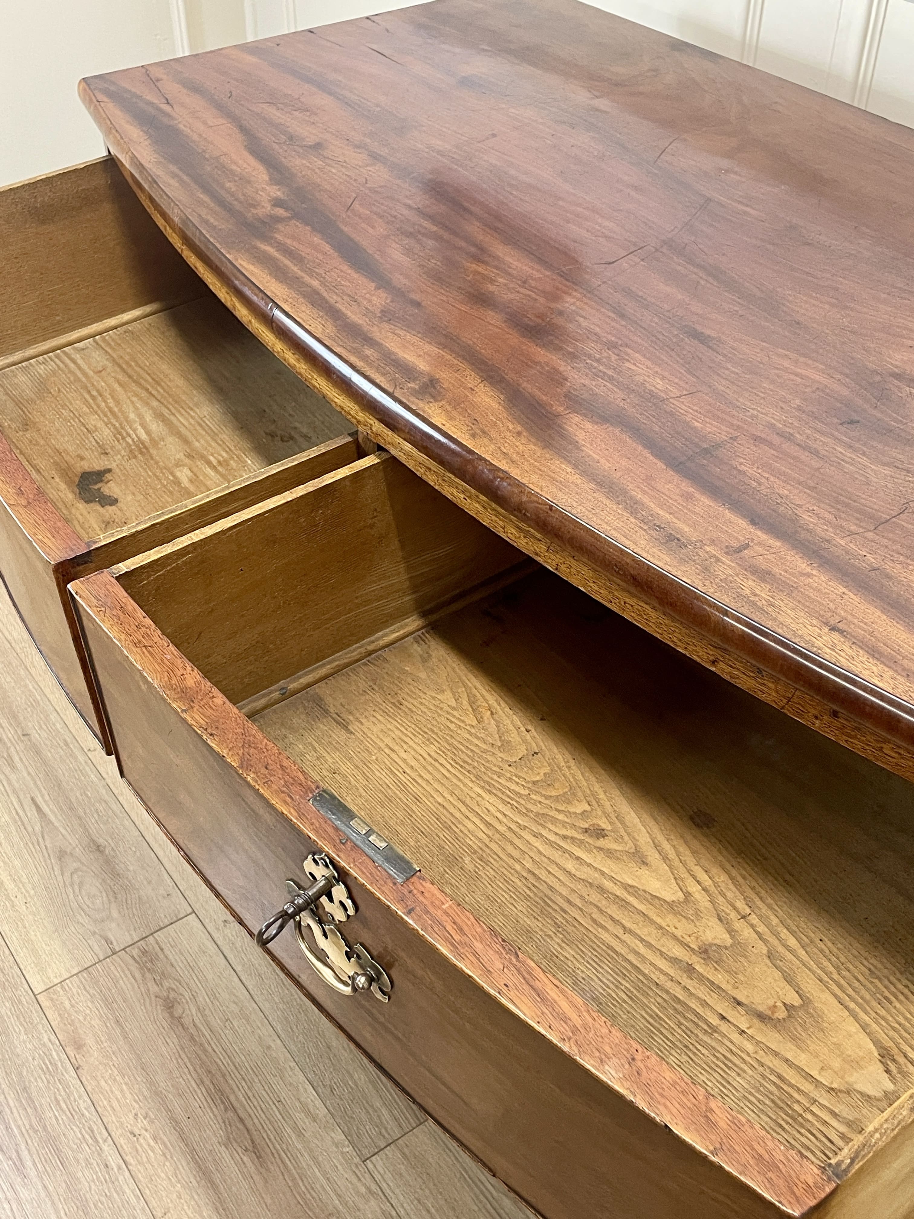 Wooden desk with an open drawer, showing wear and tear.