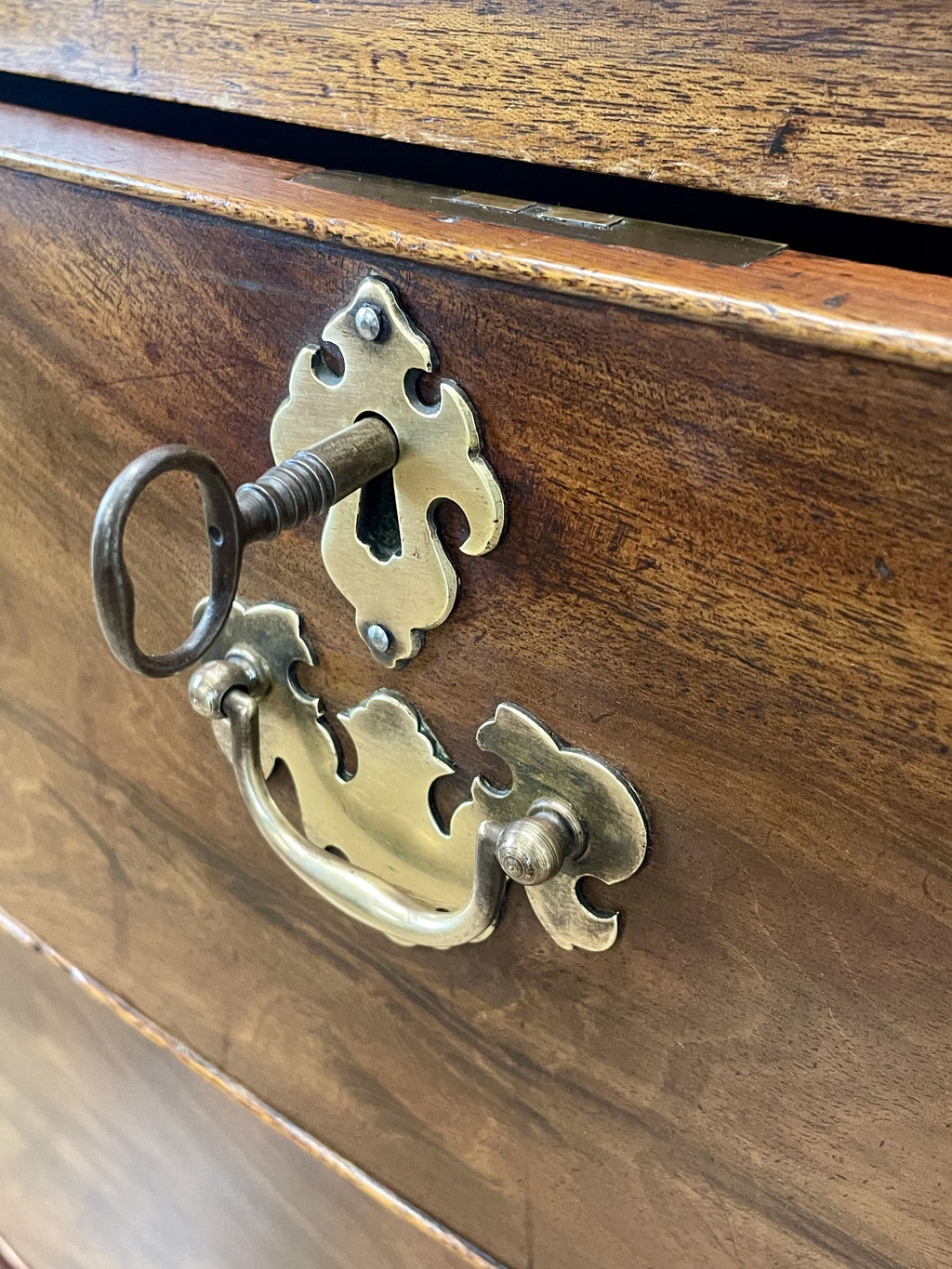 Brass keyhole and handle on a wooden surface