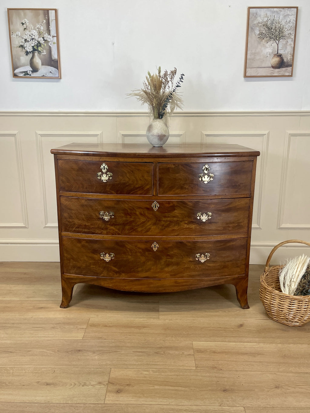 Wooden dresser with three drawers in a room with a basket and flowers on the floor.