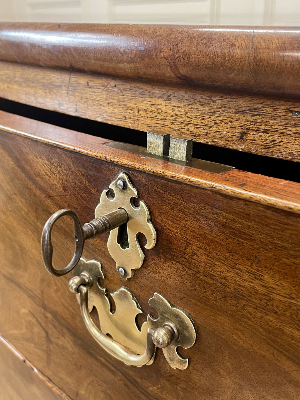 Close-up of a wooden drawer with brass handle and keyhole