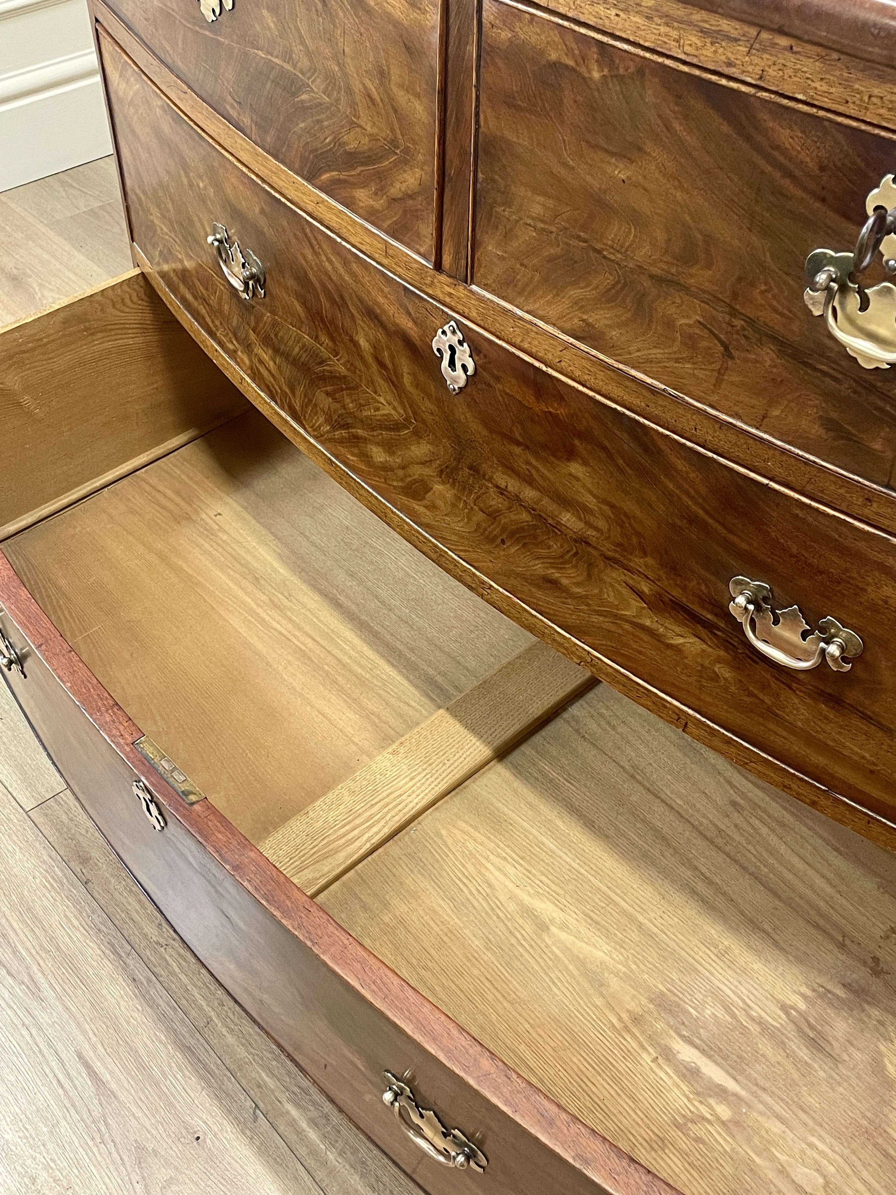 Wooden dresser with open drawer on a wooden floor