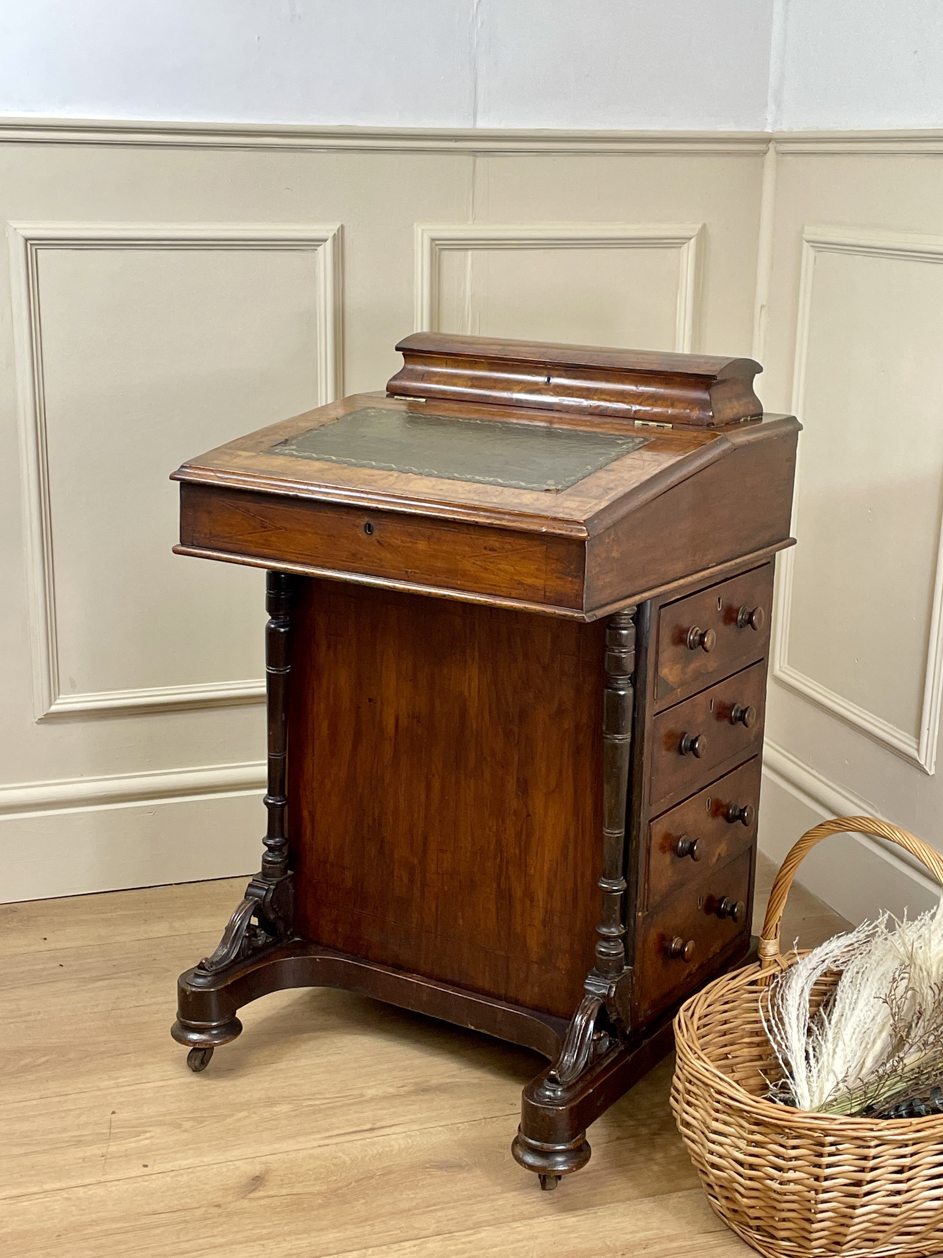 Antique Victorian Burr Walnut Davenport Writing Desk with original dark green leather top, boxwood stringing, side drawers, and turned columns on castors.