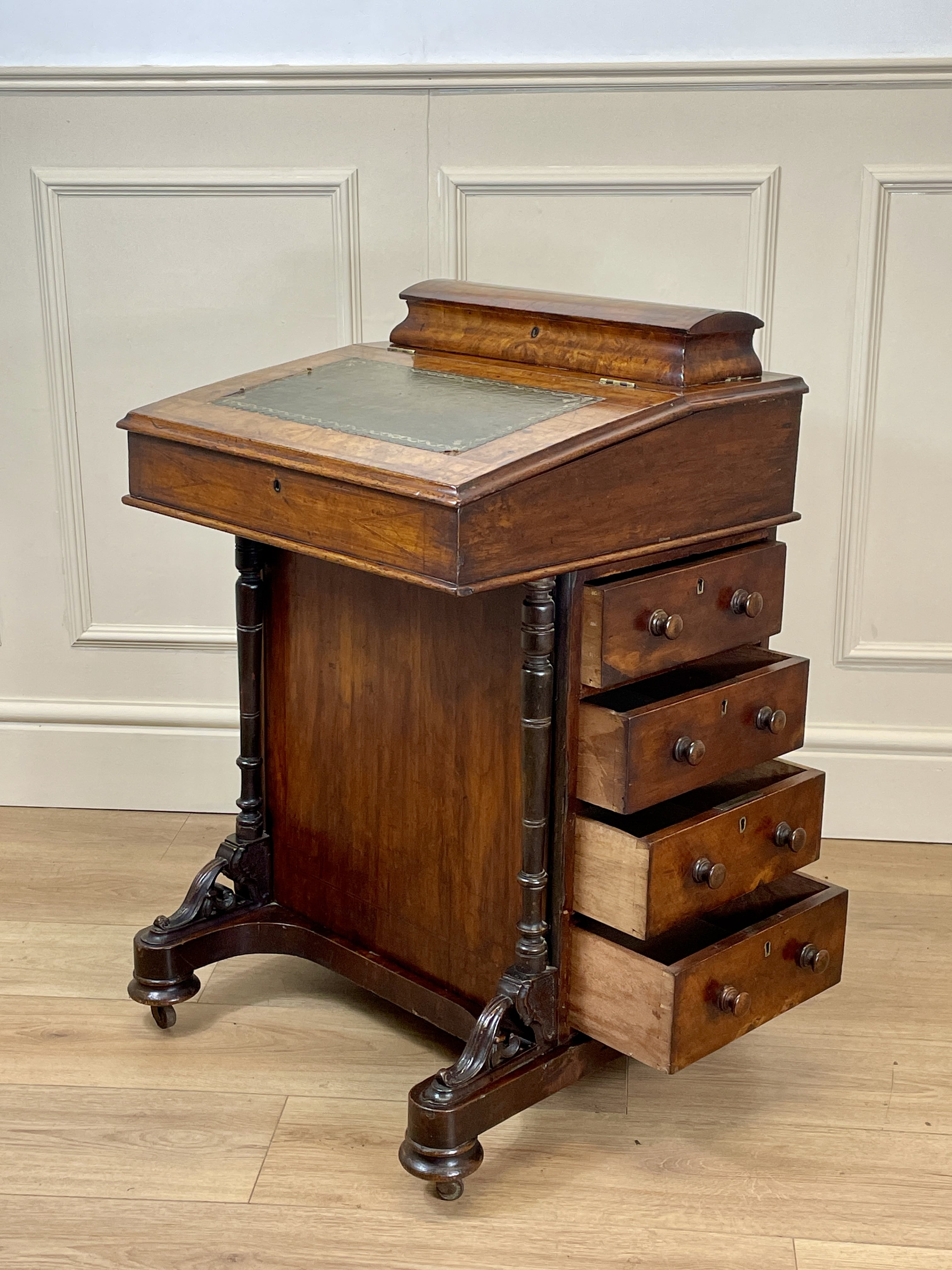 Antique Victorian Burr Walnut Davenport Writing Desk with original dark green leather top, boxwood stringing, side drawers, and turned columns on castors.