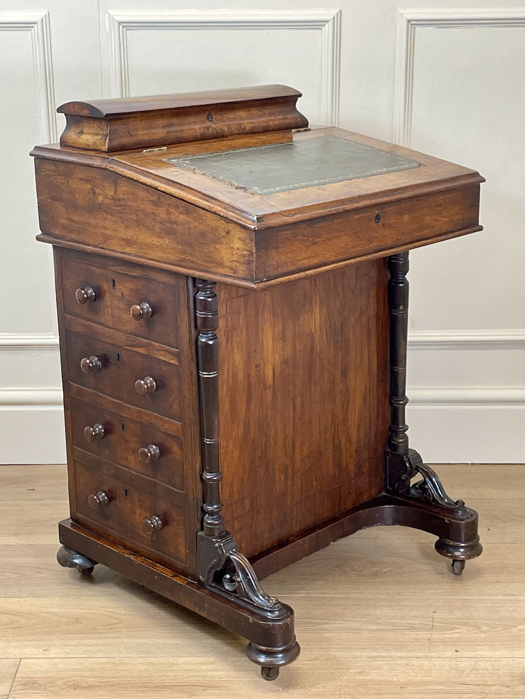 Antique Victorian Burr Walnut Davenport Writing Desk with original dark green leather top, boxwood stringing, side drawers, and turned columns on castors.