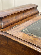 Antique Victorian Burr Walnut Davenport Writing Desk with original dark green leather top, boxwood stringing, side drawers, and turned columns on castors.