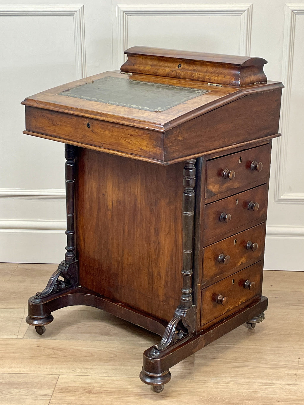 Antique Victorian Burr Walnut Davenport Writing Desk with original dark green leather top, boxwood stringing, side drawers, and turned columns on castors.