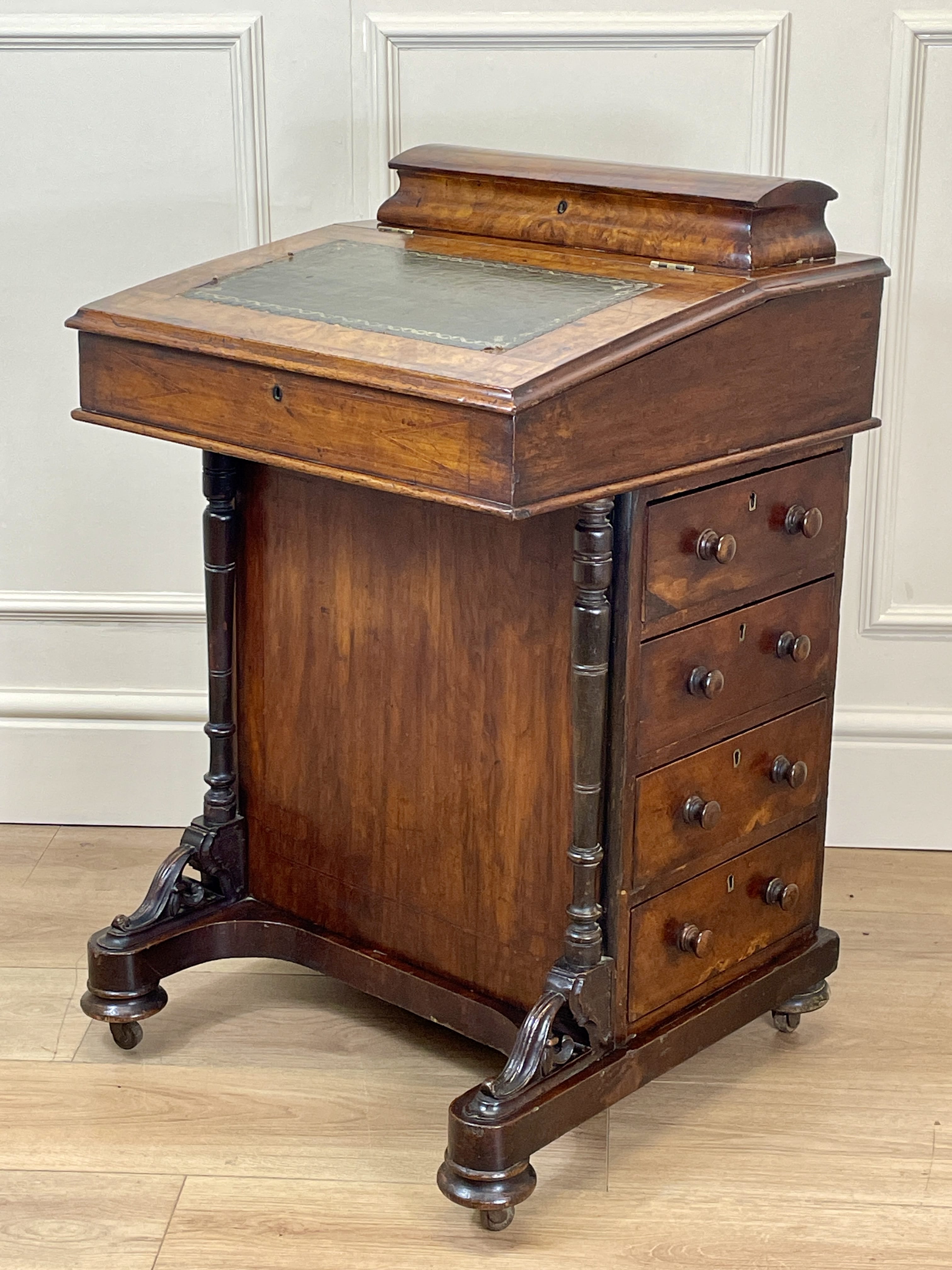 Antique Victorian Burr Walnut Davenport Writing Desk with original dark green leather top, boxwood stringing, side drawers, and turned columns on castors.