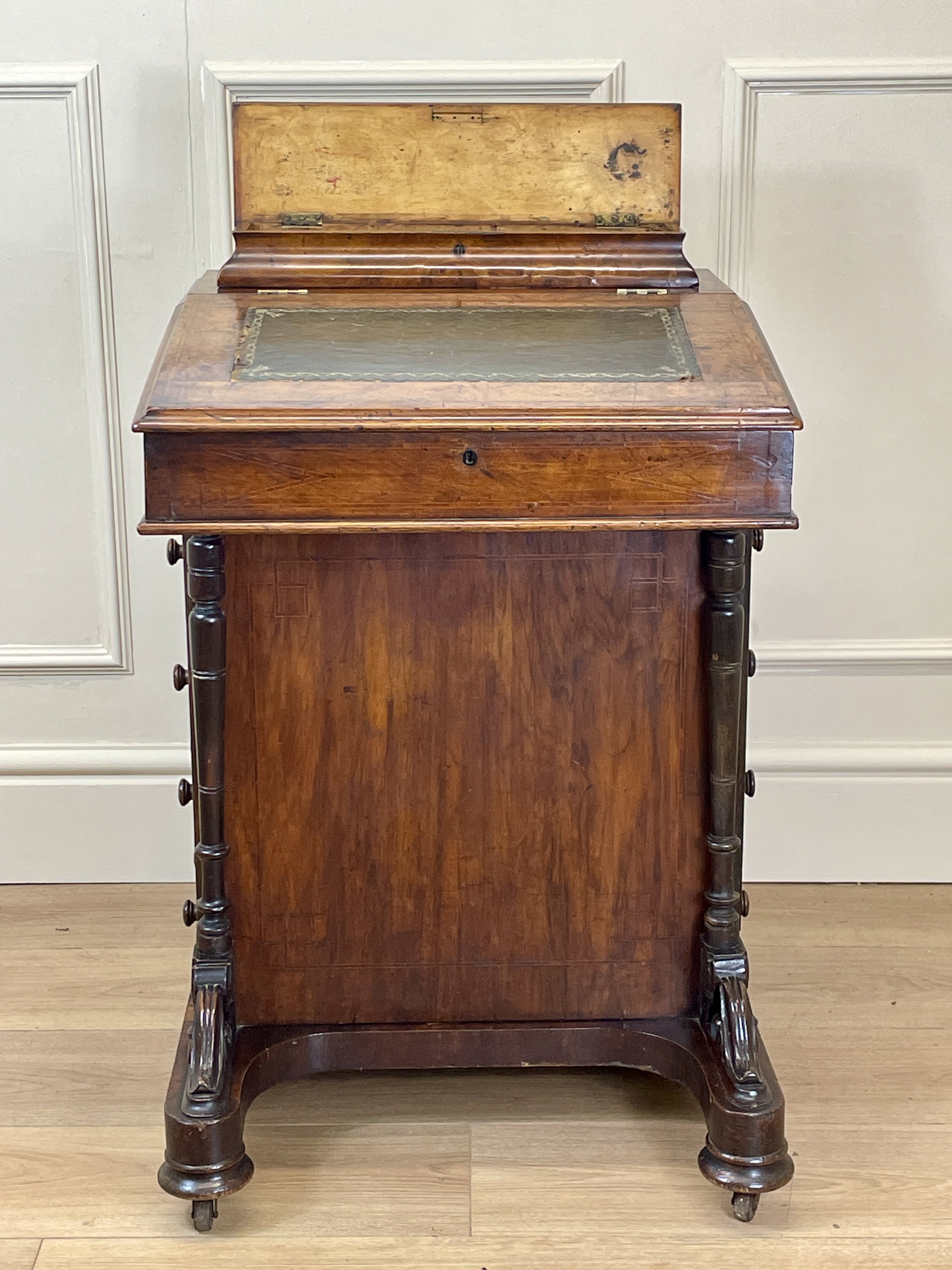 Antique Victorian Burr Walnut Davenport Writing Desk with original dark green leather top, boxwood stringing, side drawers, and turned columns on castors.
