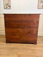 Wooden dresser with a floral arrangement in the background