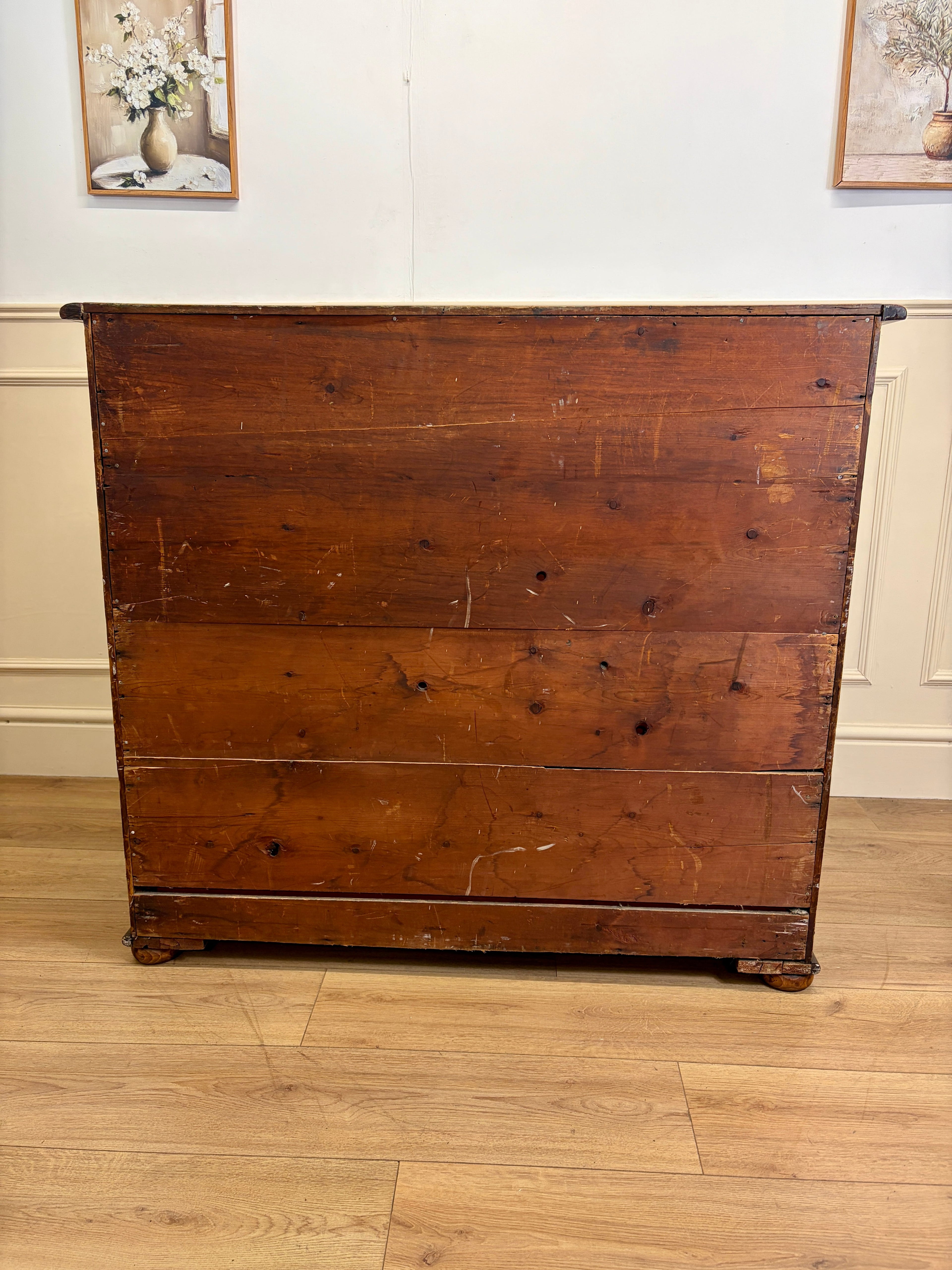 Wooden dresser with a floral arrangement in the background