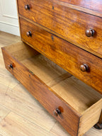 Wooden dresser with open drawer on a wooden floor