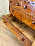 Wooden dresser with open drawer on a wooden floor